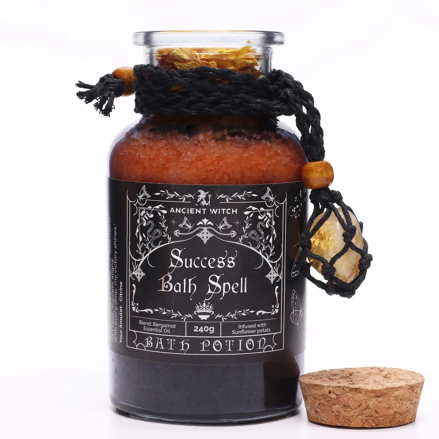 "Success Bath Spell glass jar with cork lid and macrame necklace with citrine crystal on white background"