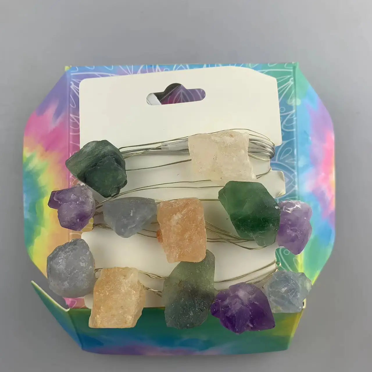 "Mixed Gemstone Crystal Lights in open pastel tie dye box showing multicoloured crystals on card wrap and USB plug on grey background"